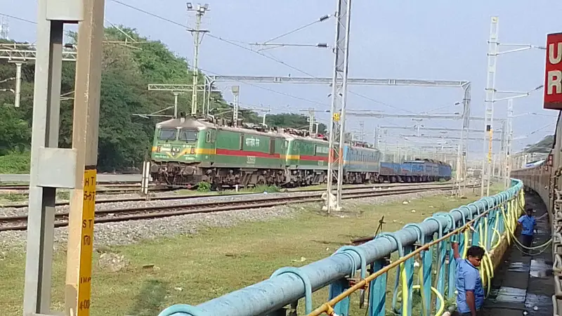 Two electric locomotives hauling a long coal train
