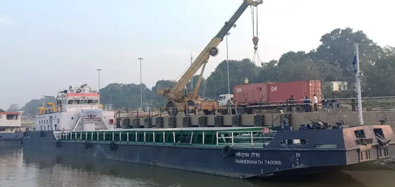 A cargo vessel berthed at Gaighat terminal in Patna while a crane loads containers